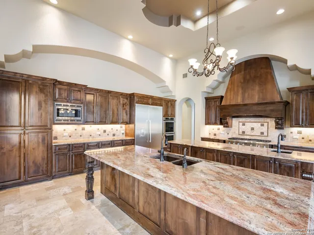 a large kitchen with kitchen island a large counter space a sink appliances and cabinets