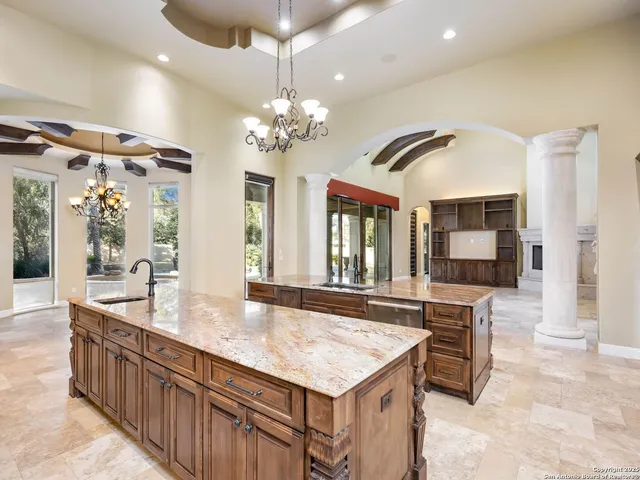 a large kitchen with kitchen island a large counter space dining table and stainless steel appliances