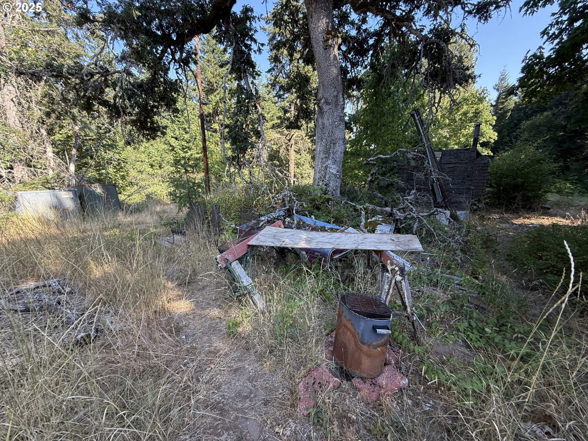 121 Cooke Road White Salmon, WA 98672 - Photo 29 of 48 a backyard of a house with table and chairs under an umbrella