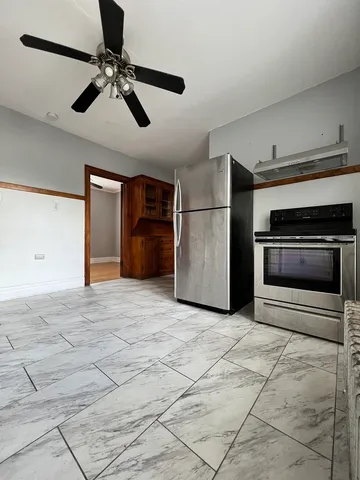 a view of a livingroom with a ceiling fan and staircase
