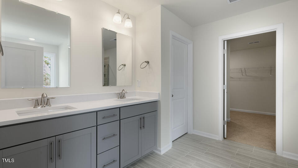 166 Red Jasper Way Clayton, NC 27520 - Photo 22 of 41 a bathroom with a double vanity sink and mirror