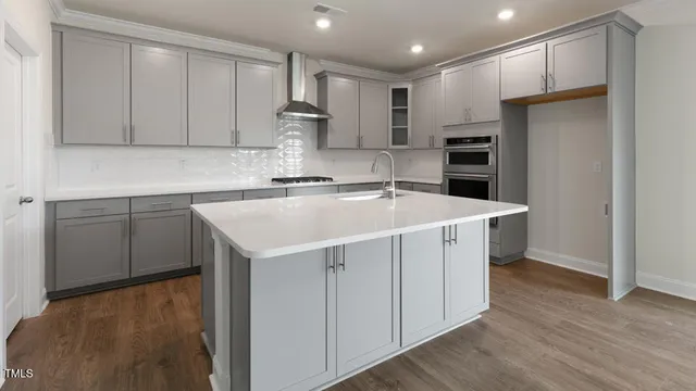 a kitchen with a sink cabinets and wooden floor
