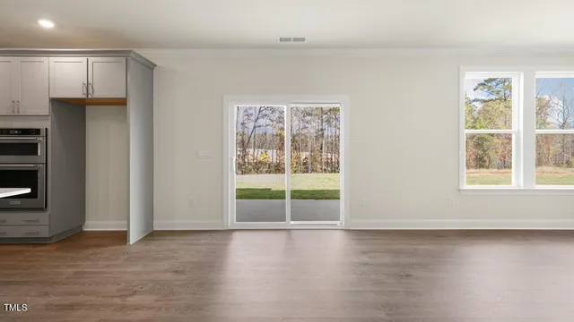 a view of a kitchen with wooden floor and electronic appliances