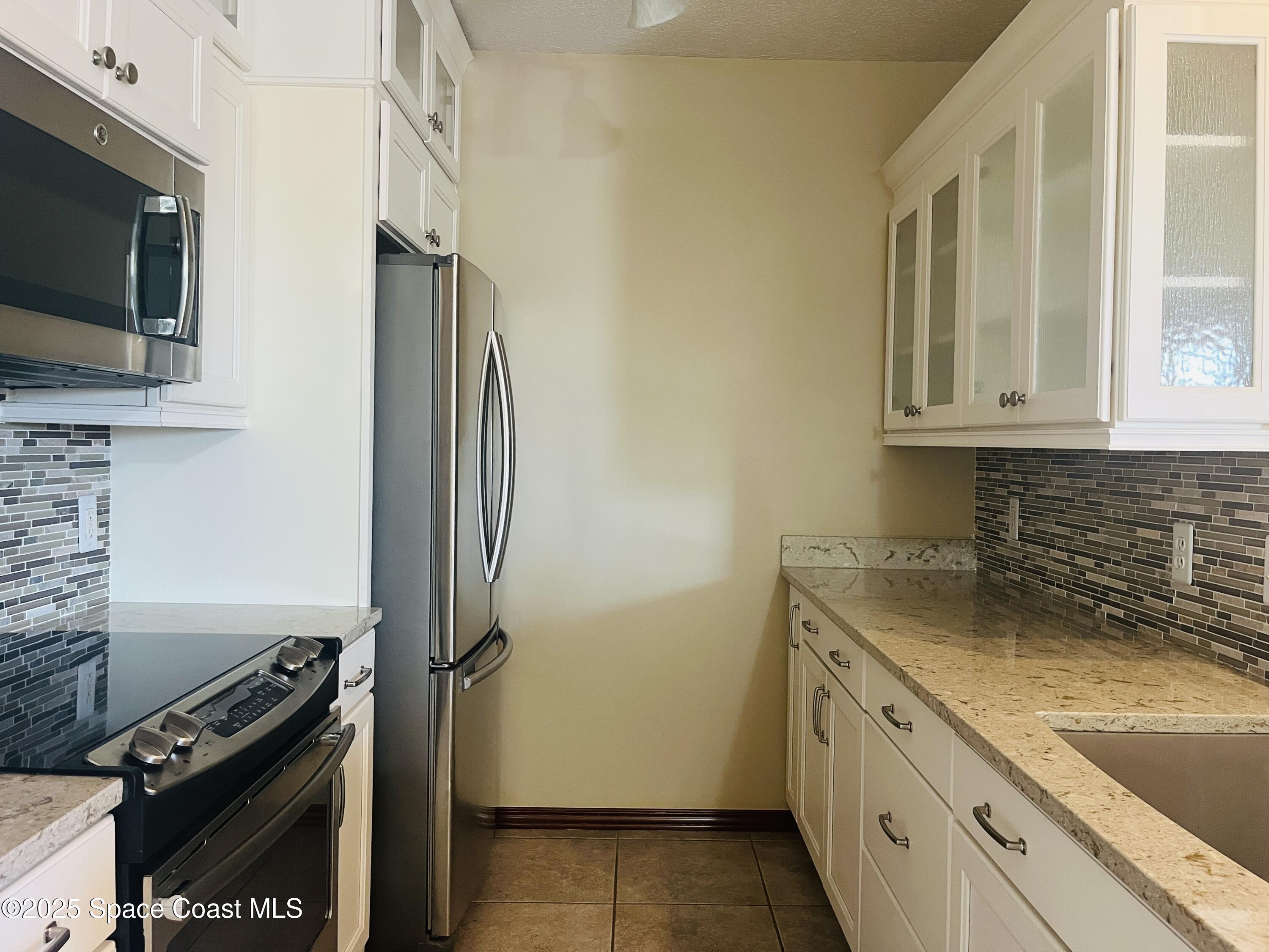 3 Florida Avenue, Unit B Cocoa, FL 32922 - Photo 3 of 10 a kitchen with a refrigerator stove and microwave