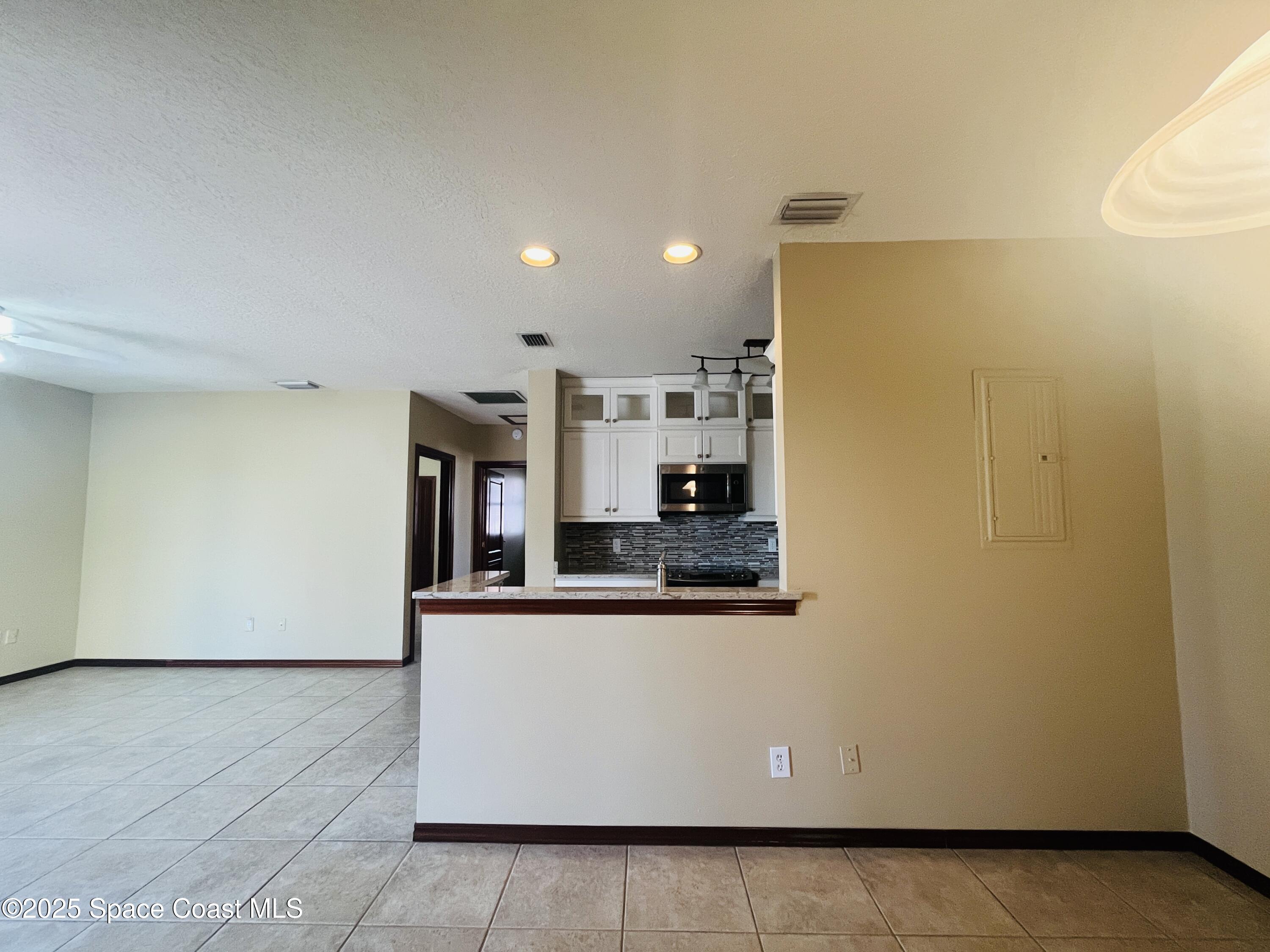 3 Florida Avenue, Unit B Cocoa, FL 32922 - Photo 4 of 10 a view of a kitchen with stainless steel appliances wooden floor and a large window