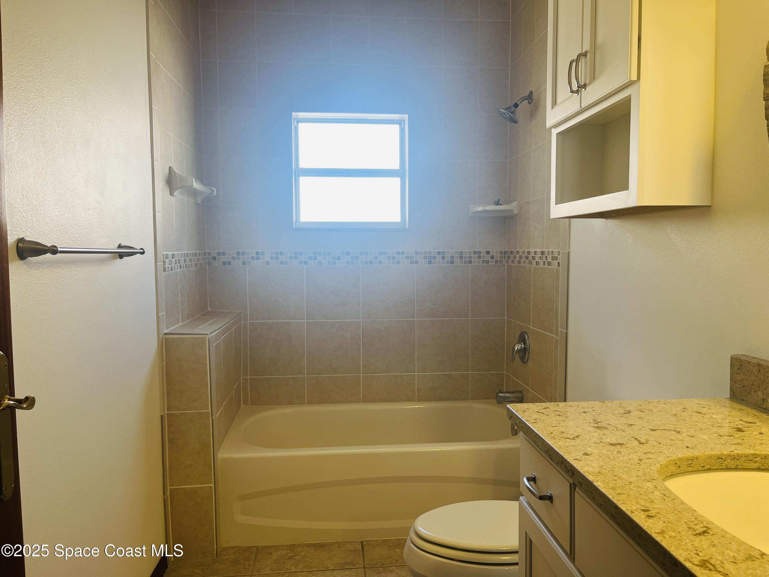 3 Florida Avenue, Unit B Cocoa, FL 32922 - Photo 10 of 10 a bathroom with a granite countertop toilet sink and bathtub