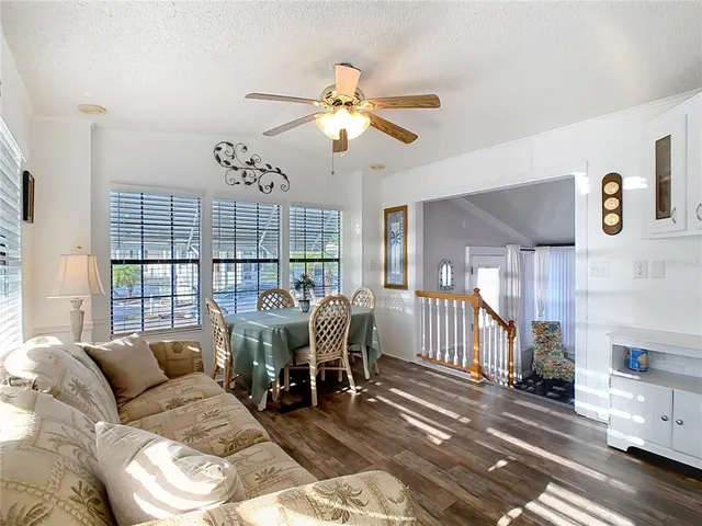 a living room with furniture a chandelier and a dining table