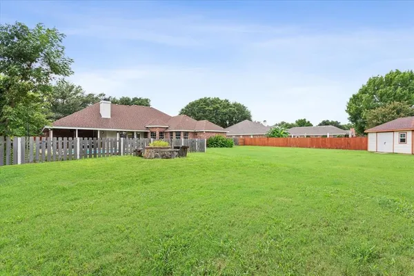 a front view of house with yard and trees in the background
