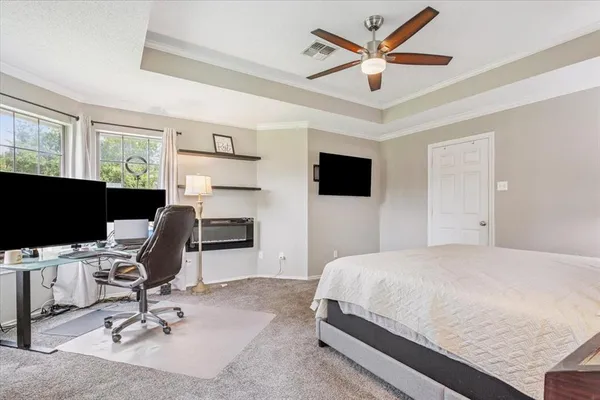 a bedroom with a bed window and a flat screen tv