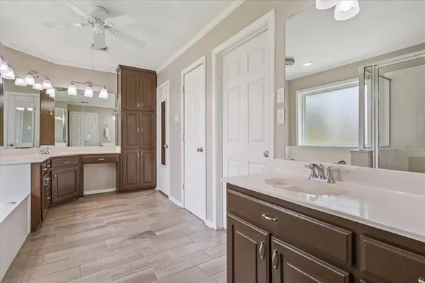 a bathroom with a sink double vanity granite tub shower and a mirror