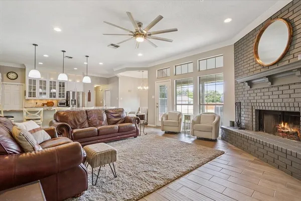 a living room with furniture a large window and a fireplace