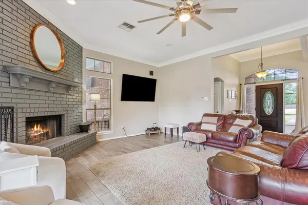 a living room with furniture a fireplace and a flat screen tv