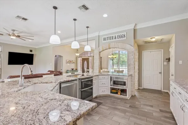 a kitchen with stainless steel appliances granite countertop a stove a sink and a refrigerator