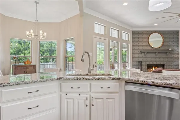 a bathroom with a granite countertop sink mirror and window
