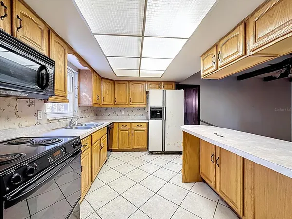 a kitchen with a refrigerator and a stove top oven