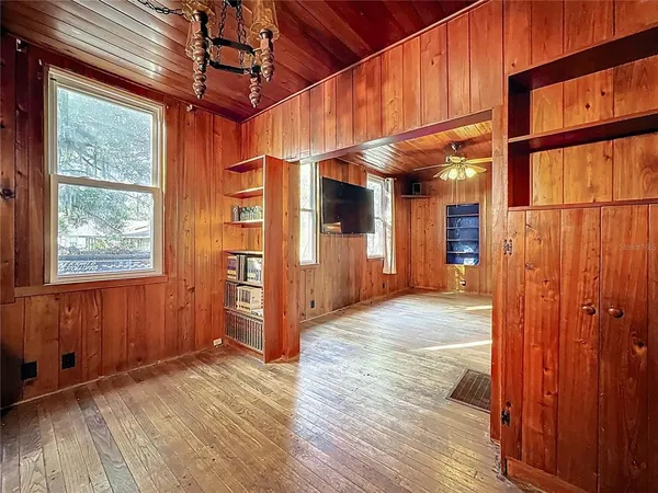 en empty room with a large window and ceiling fan