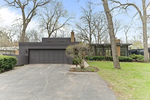 a view of a house with a yard and large tree