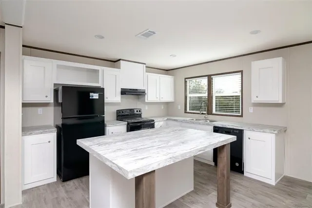 a kitchen with a stove a sink dishwasher a refrigerator and a microwave oven with wooden floor