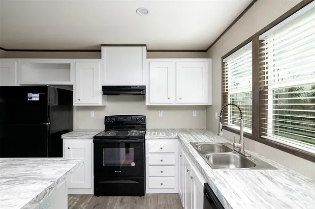 a kitchen with granite countertop a stove and a sink