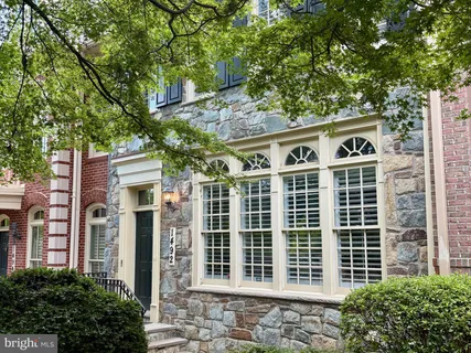 a front view of a building with a tree