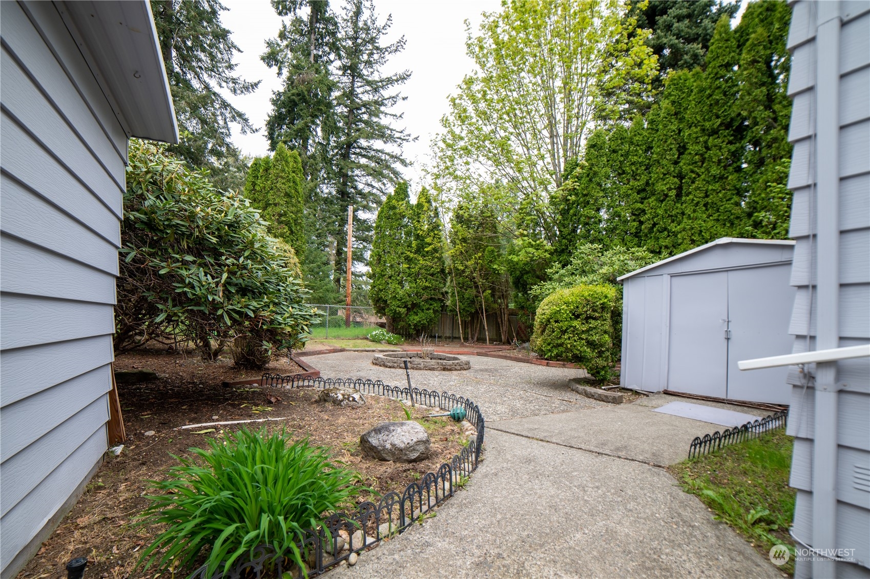 1121 244th Street Southwest, Unit 2 Bothell, WA 98021 - Photo 24 of 31 a view of a backyard with potted plants and large tree