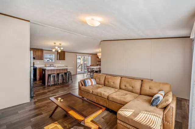 a living room with furniture a fireplace and a dining table with wooden floor