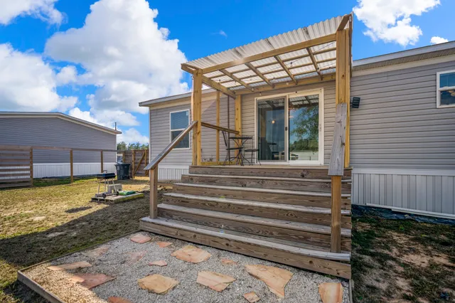 a view of a house with a large window and wooden fence
