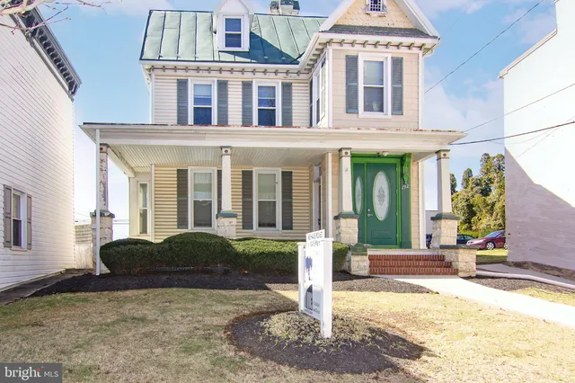 a front view of a house with a yard and potted plants
