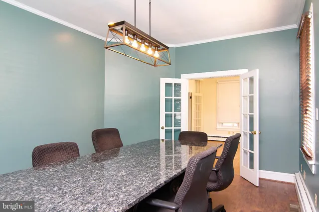 a view of a hallway with wooden floor and a bathroom