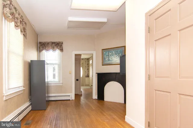 a view of a hallway to a room with wooden floor