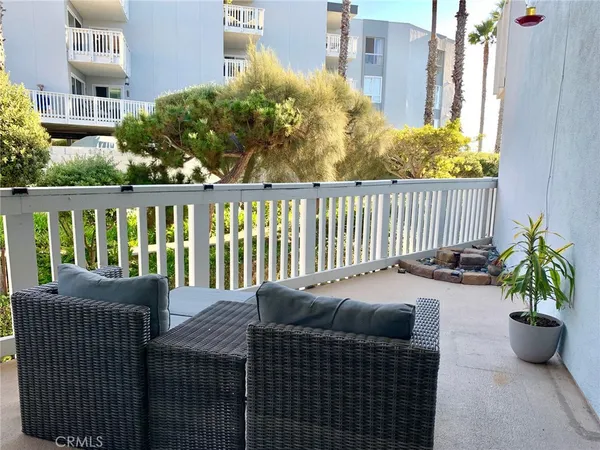 a balcony with wooden floor table and chairs