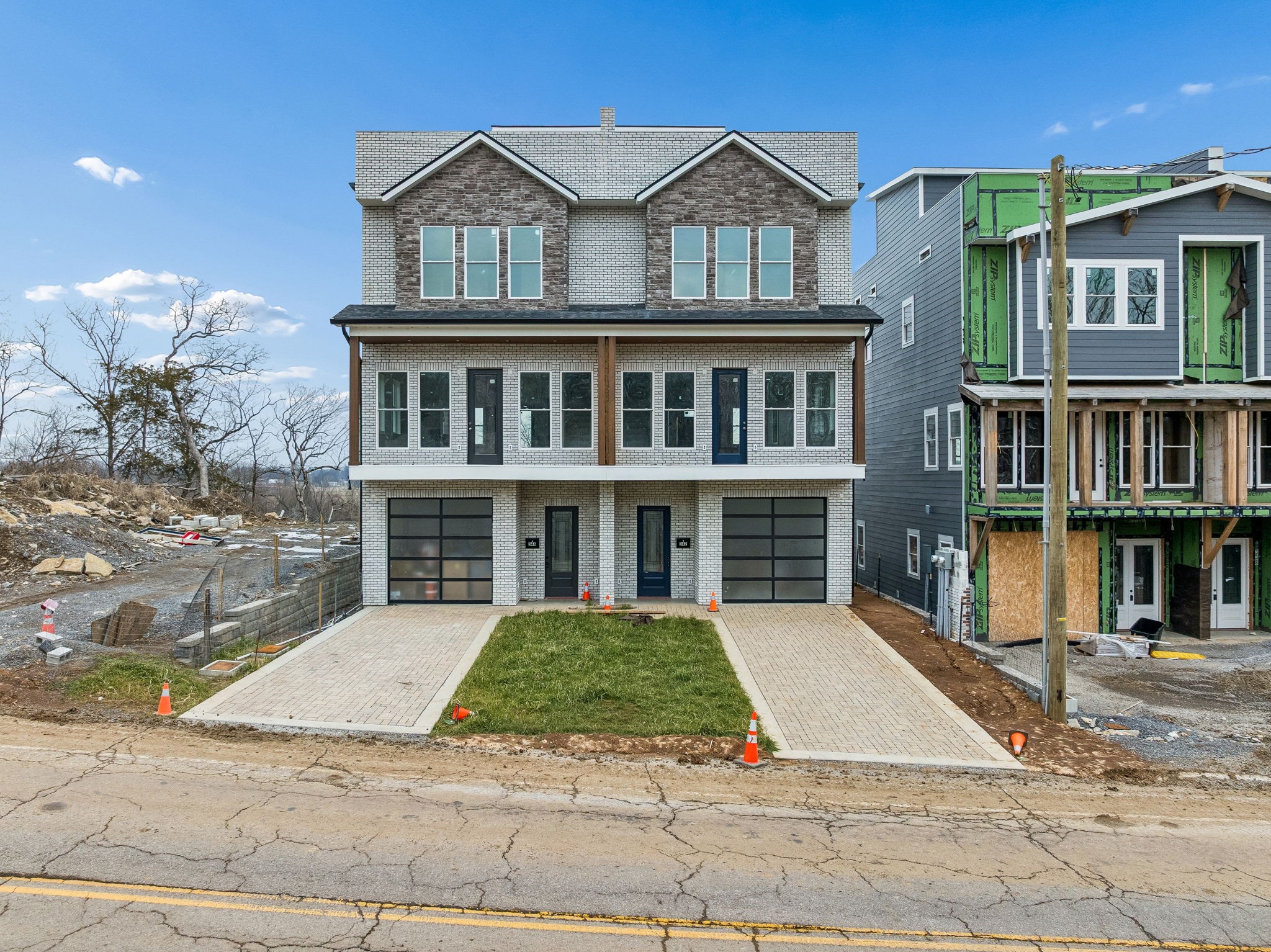 a view of a brick house with many windows next to a road