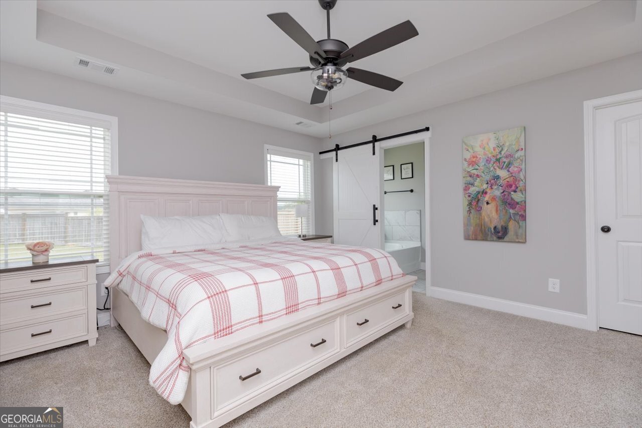104 Meredith Layne Court Perry, GA 31069 - Photo 22 of 46 a bed room with a bed and a ceiling fan
