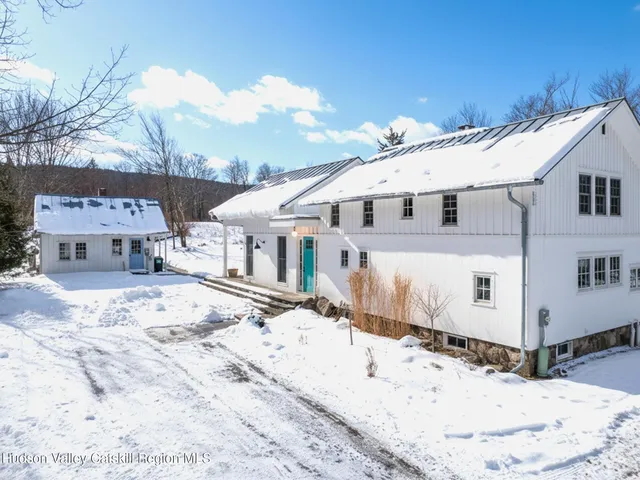a view of a white house with a snow on the road