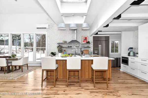 a dining room with wooden floor and white walls