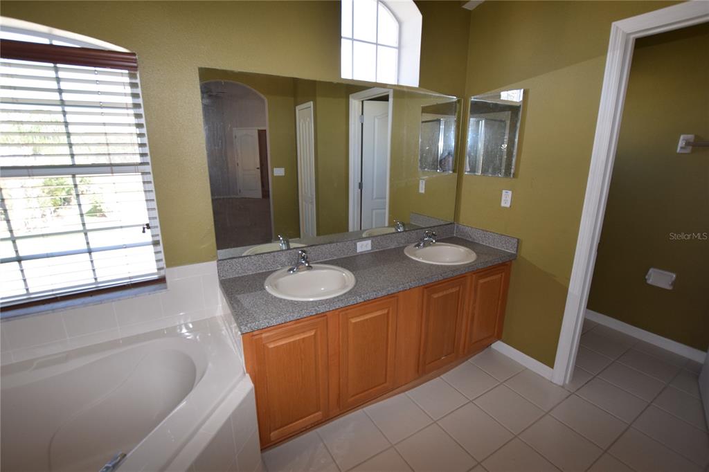 3118 Riachuelo Lane Kissimmee, FL 34744 - Photo 19 of 26 a bathroom with a granite countertop sink and a mirror