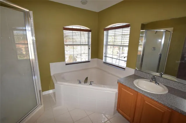 a bathroom with a granite countertop sink and a bathtub