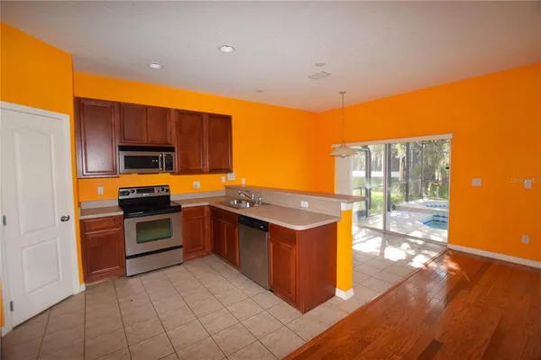 a kitchen with stainless steel appliances granite countertop a stove a sink and a refrigerator