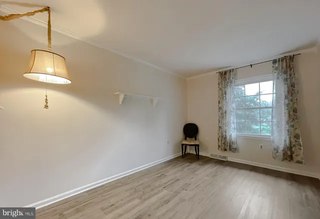 a kitchen with stainless steel appliances granite countertop a refrigerator a oven a stove and a dining table with wooden floor