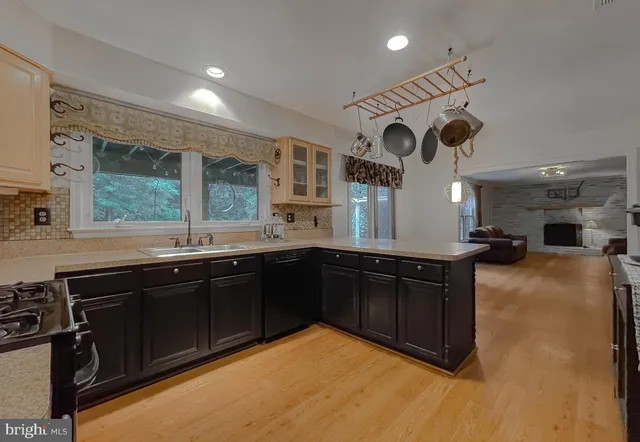 a kitchen with stainless steel appliances granite countertop a stove a sink dishwasher and a microwave oven with white cabinets