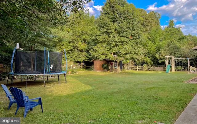 an aerial view of a house with a yard and greenery