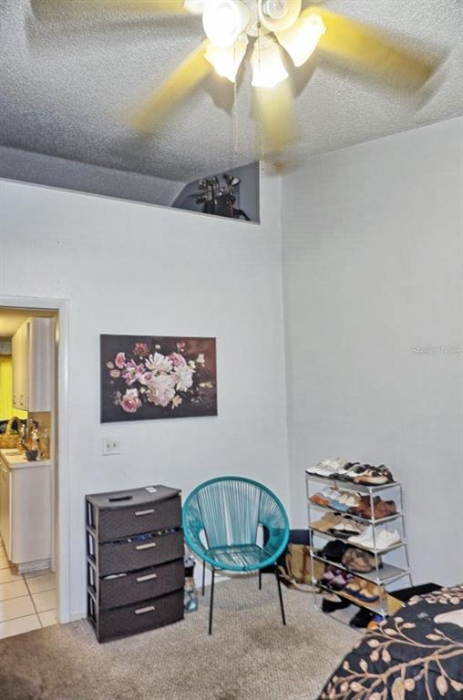 20857 Haulover Cove Road, Unit B14 Lutz, FL 33558 - Photo 17 of 35 a bedroom with furniture and a chair
