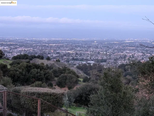 an aerial view of house with yard and mountain view in back