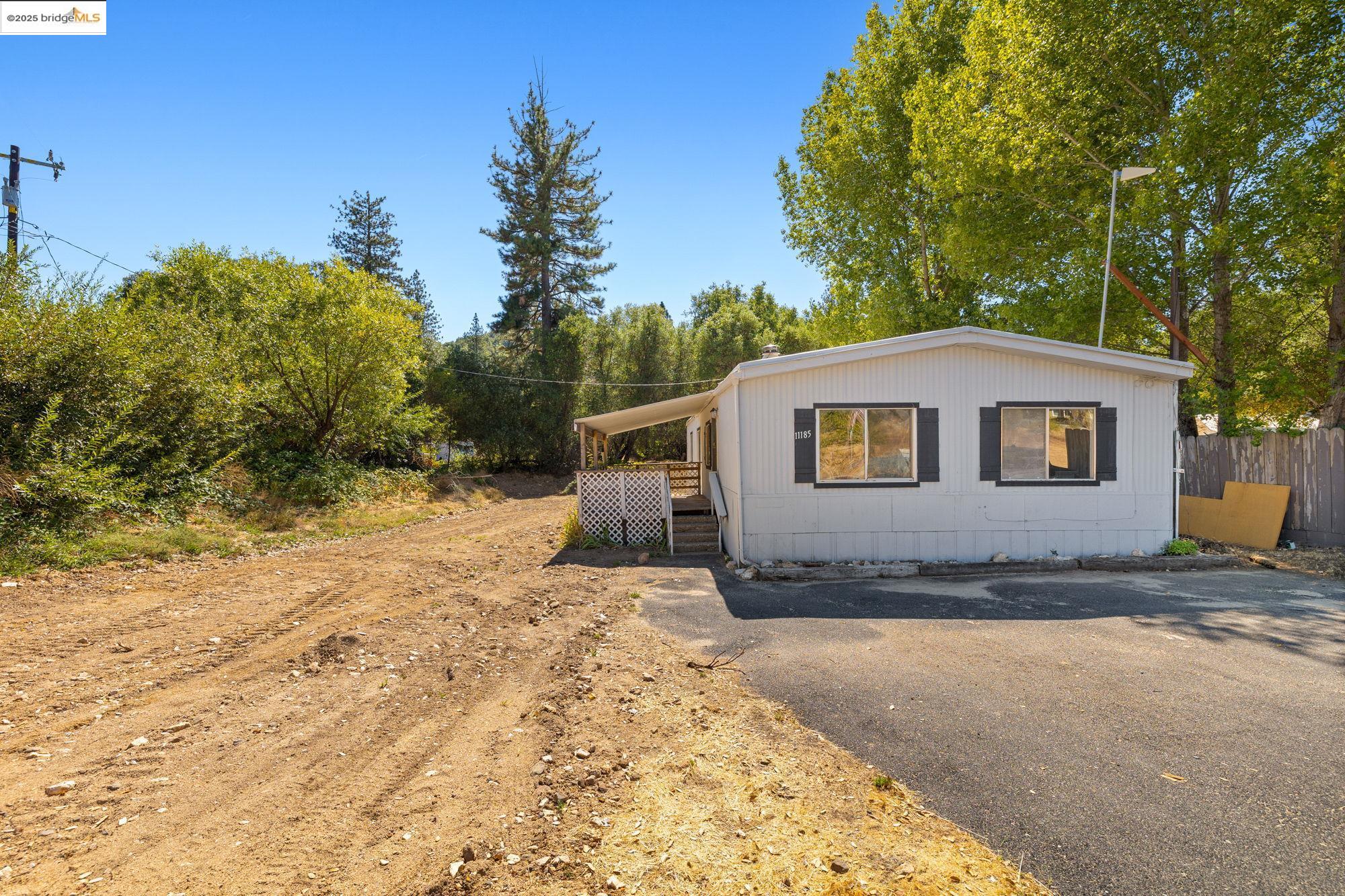 Manufactured / mobile home with a wooden deck and asphalt driveway