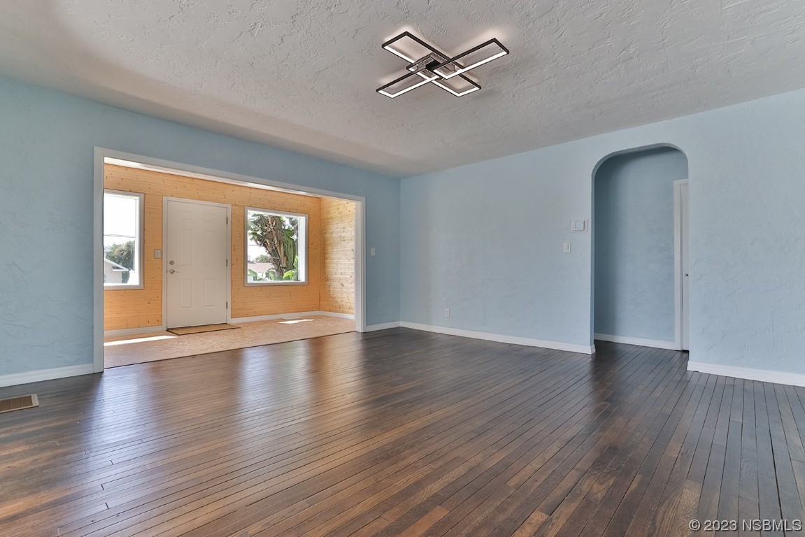 133 Milton Road Daytona Beach, FL 32118 - Photo 13 of 70 an empty room with wooden floor chandelier and windows