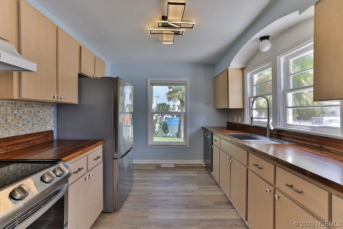 133 Milton Road Daytona Beach, FL 32118 - Photo 16 of 70 a kitchen with stainless steel appliances granite countertop a stove a sink and a refrigerator