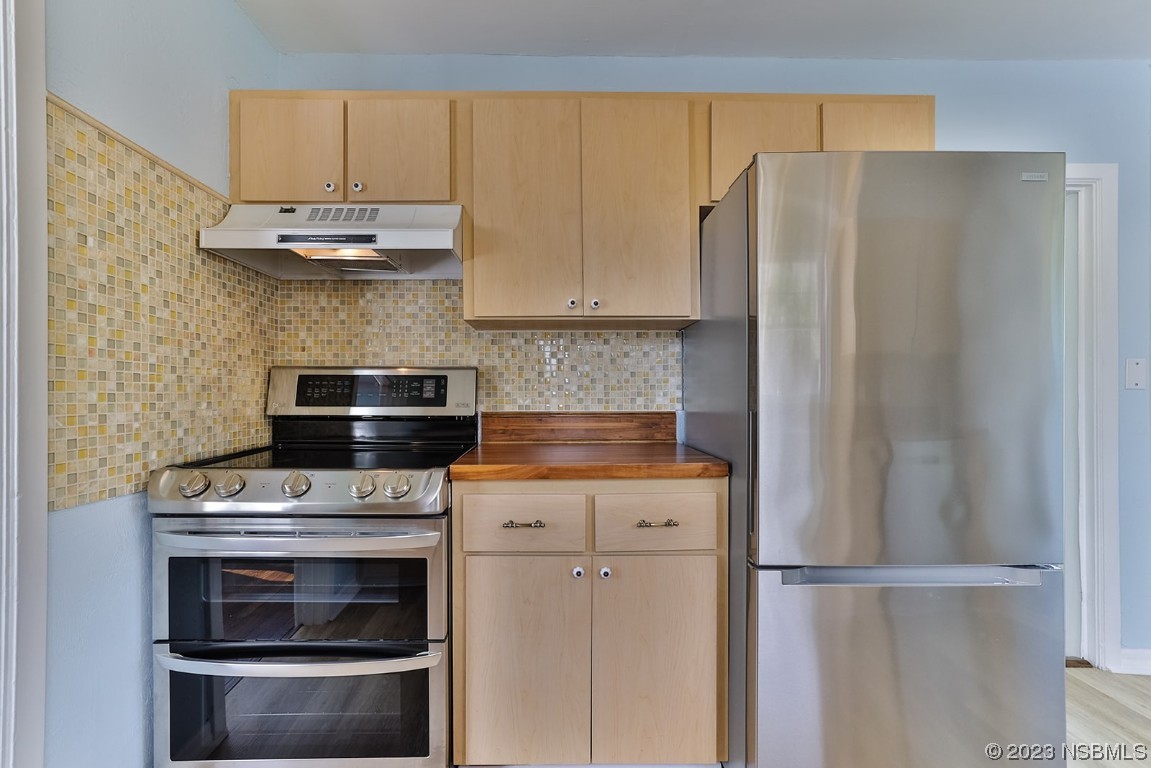 133 Milton Road Daytona Beach, FL 32118 - Photo 21 of 70 a kitchen with stainless steel appliances wooden floor sink and stove