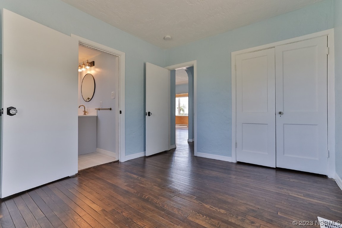 133 Milton Road Daytona Beach, FL 32118 - Photo 22 of 70 a view of an empty room with wooden floor and mirror