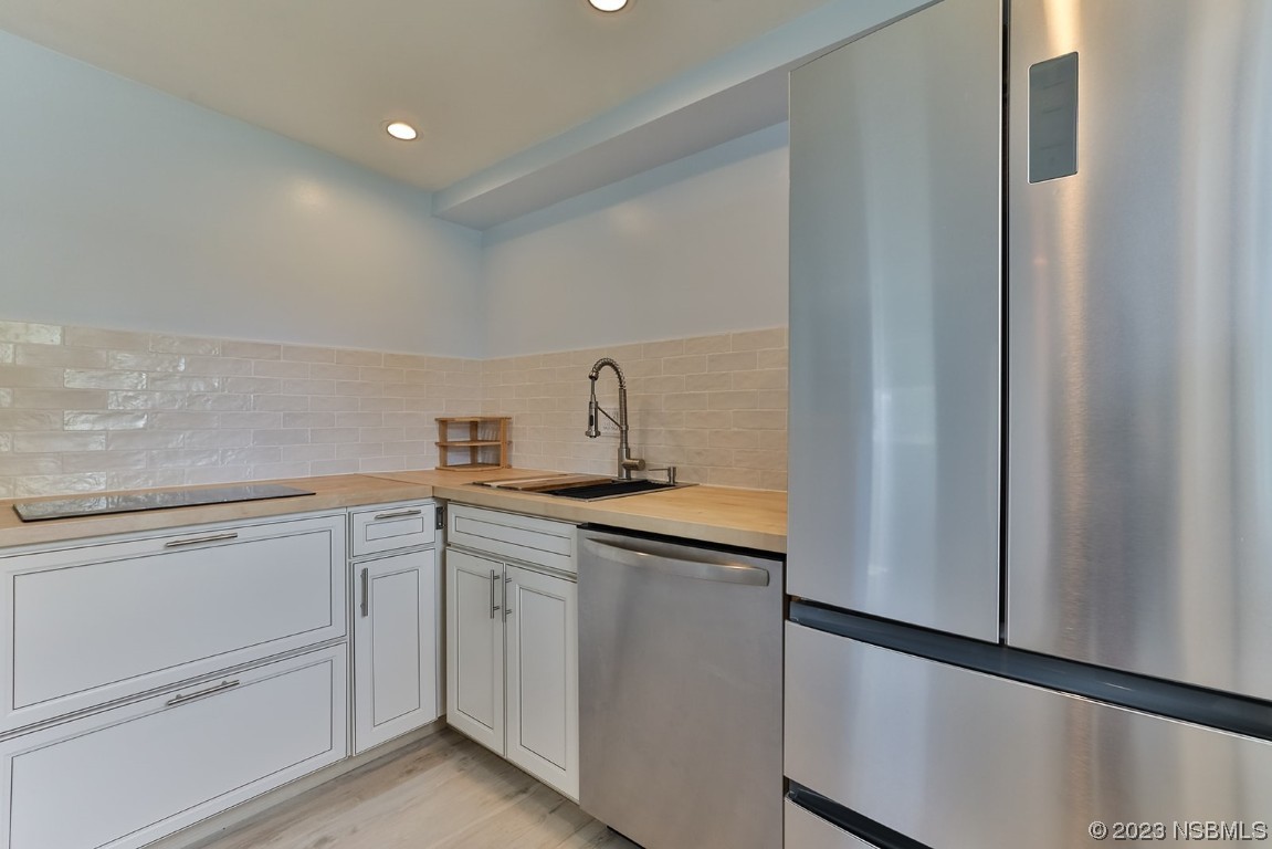 133 Milton Road Daytona Beach, FL 32118 - Photo 40 of 70 a kitchen with white cabinets sink and stove