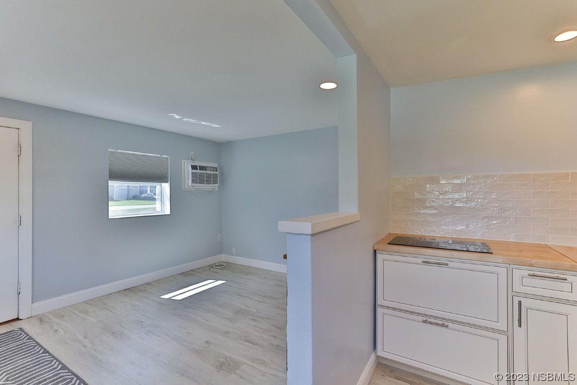 133 Milton Road Daytona Beach, FL 32118 - Photo 45 of 70 a view of a kitchen with white cabinets and a wooden floor